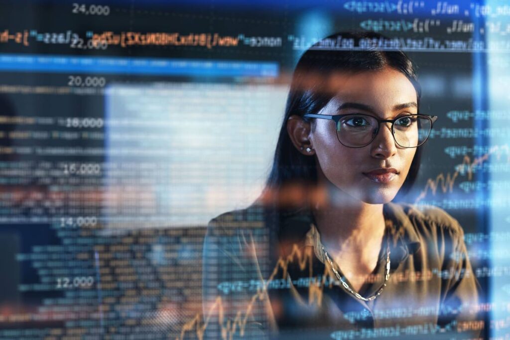 A woman looking at code on a computer.