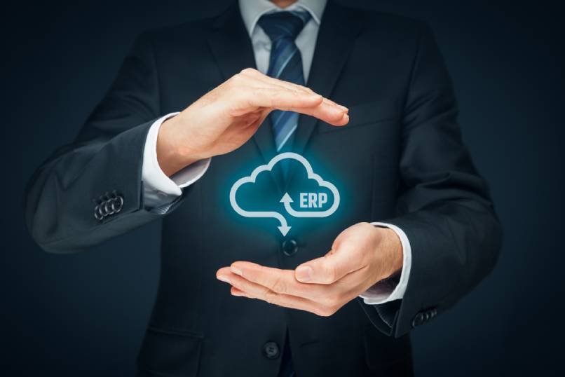 A businessperson holds a cloud ERP symbol in their hands.