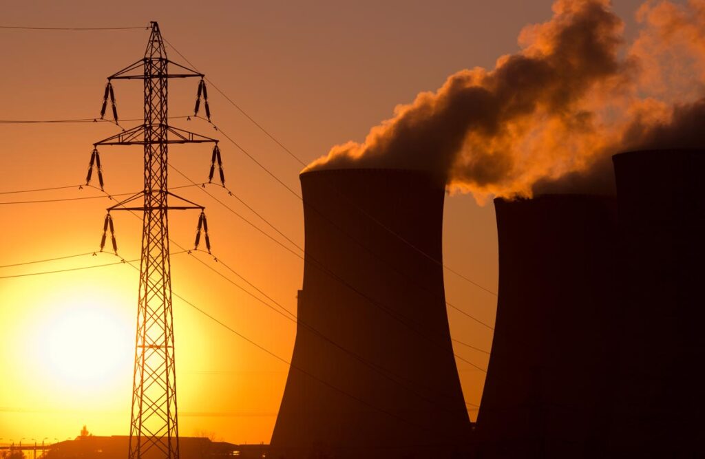 Cooling towers at sunset next to a power line