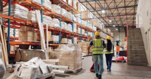 People in PPE walking through a warehouse 