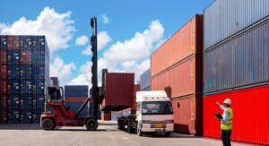 A forklift loading a container onto the back of a semi truck 