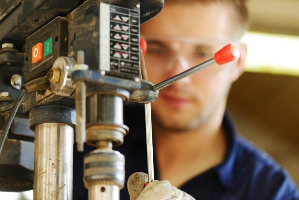 A machinist using a drill press.
