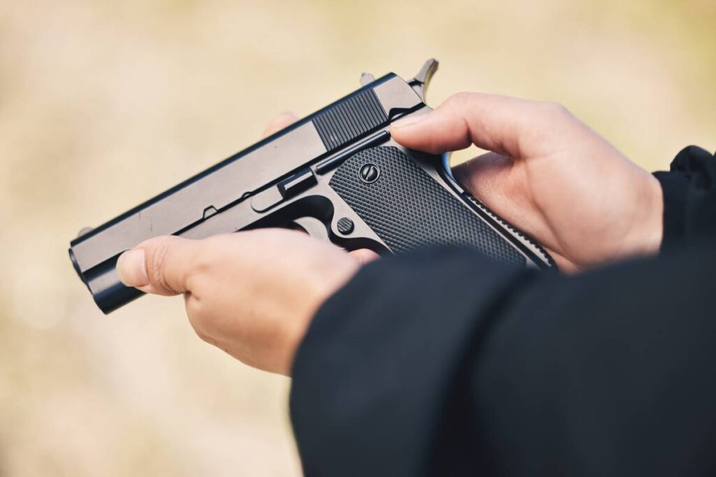 A closeup of hands holding a pistol.