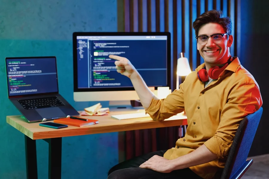 A happy young businessman sitting at his workstation.