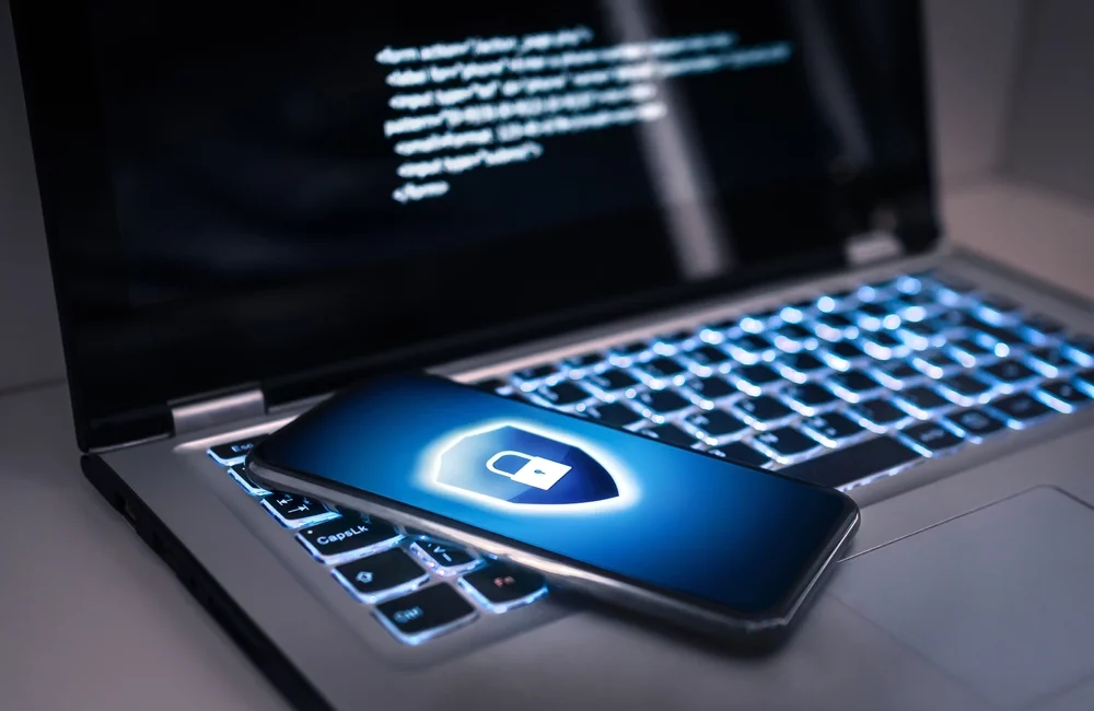 A laptop with a phone on a lock screen.