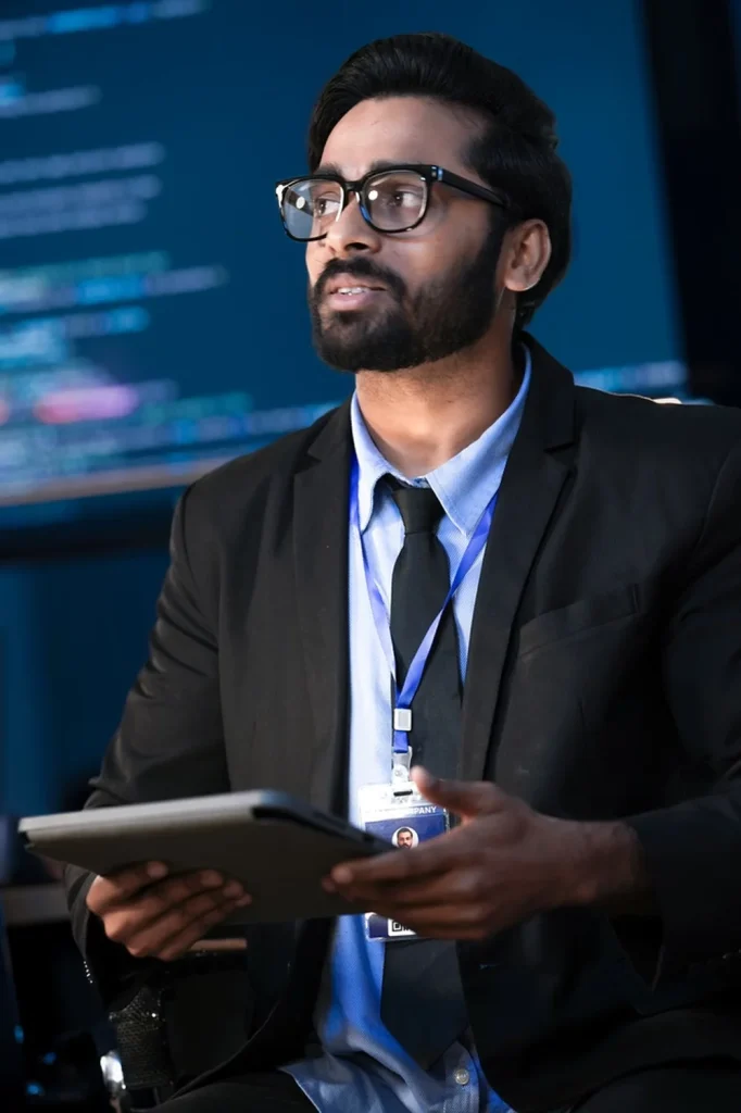 A cybersecurity professional holding a tablet at a conference.