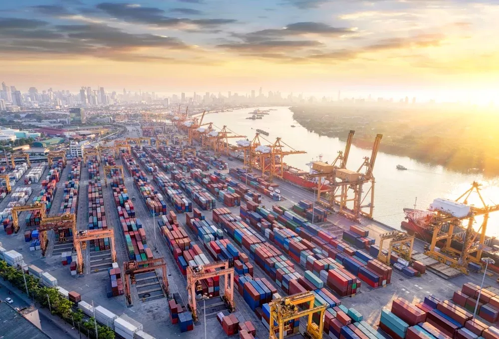 An aerial view of a large port with cranes and shipping containers.