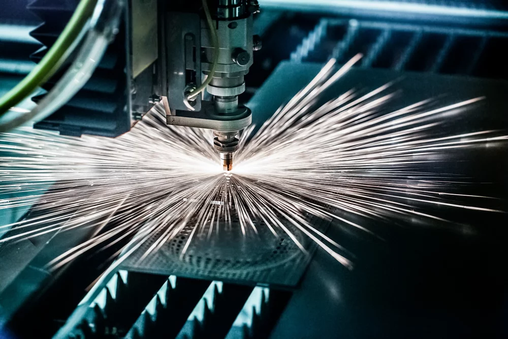 A CNC laser cutting a piece of metal.